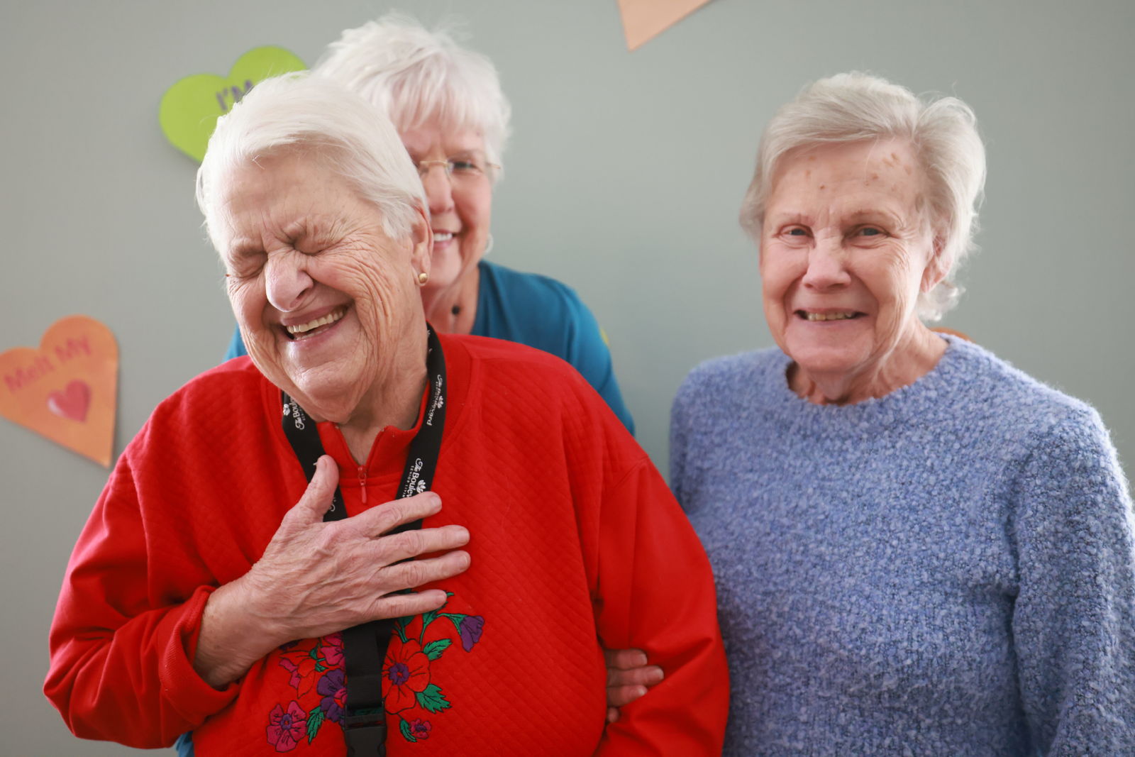 Senior women who live at an Arrow Senior Living community smiling and laughing together, celebrating Galentines day