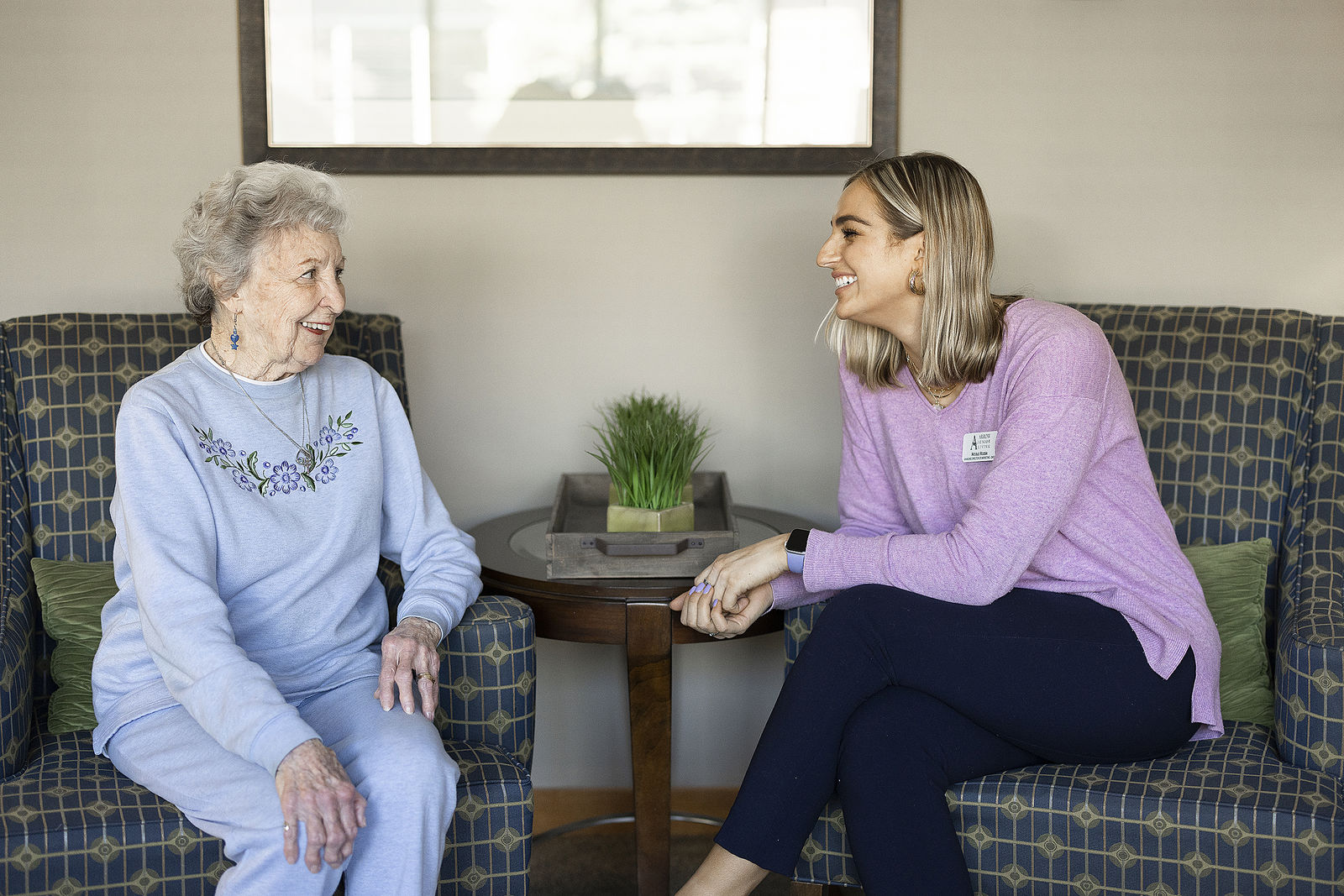 Woman who resides in memory care community talking with caregiver