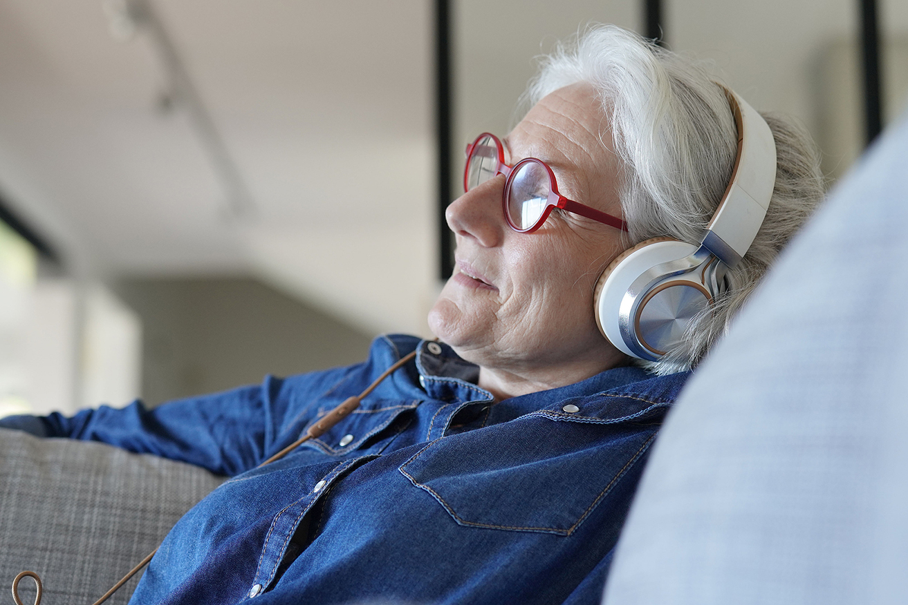 Senior woman wearing headphones to listen to music and relax
