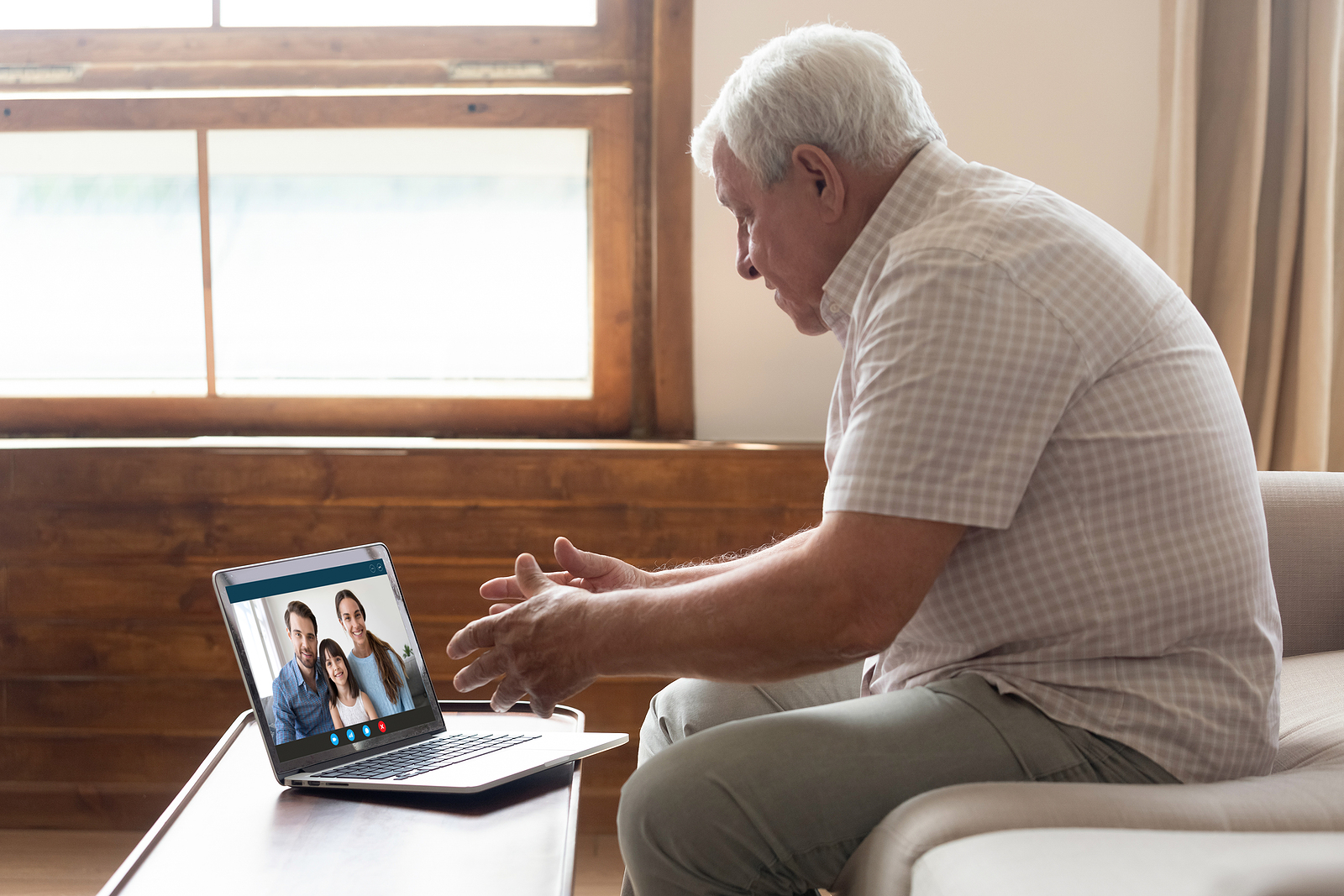 Senior using video conferencing on laptop to virtually tour a senior living community for aging in place