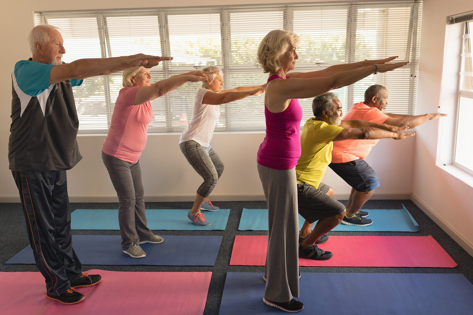 Six senior citizens taking a gentle yoga class at their senior living community 