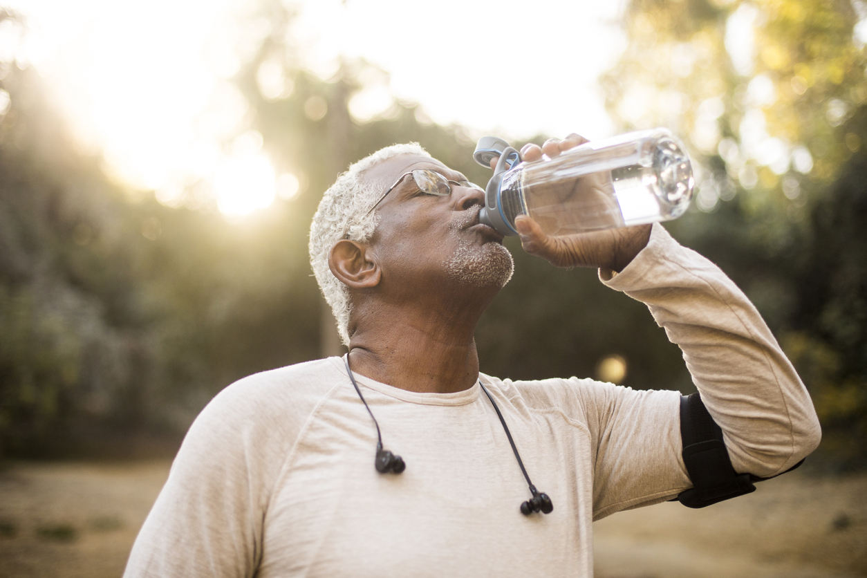 Senior man drinking water after spending time outdoors