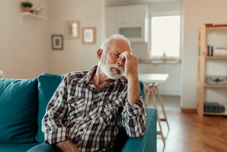 Senior man sitting on home struggling with symptoms of anxiety and depression
