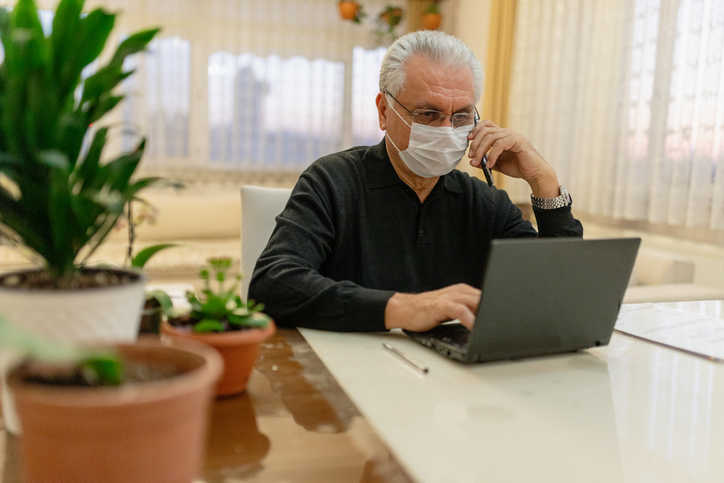 Senior man wearing mask researching covid-19 prevention best practices for seniors