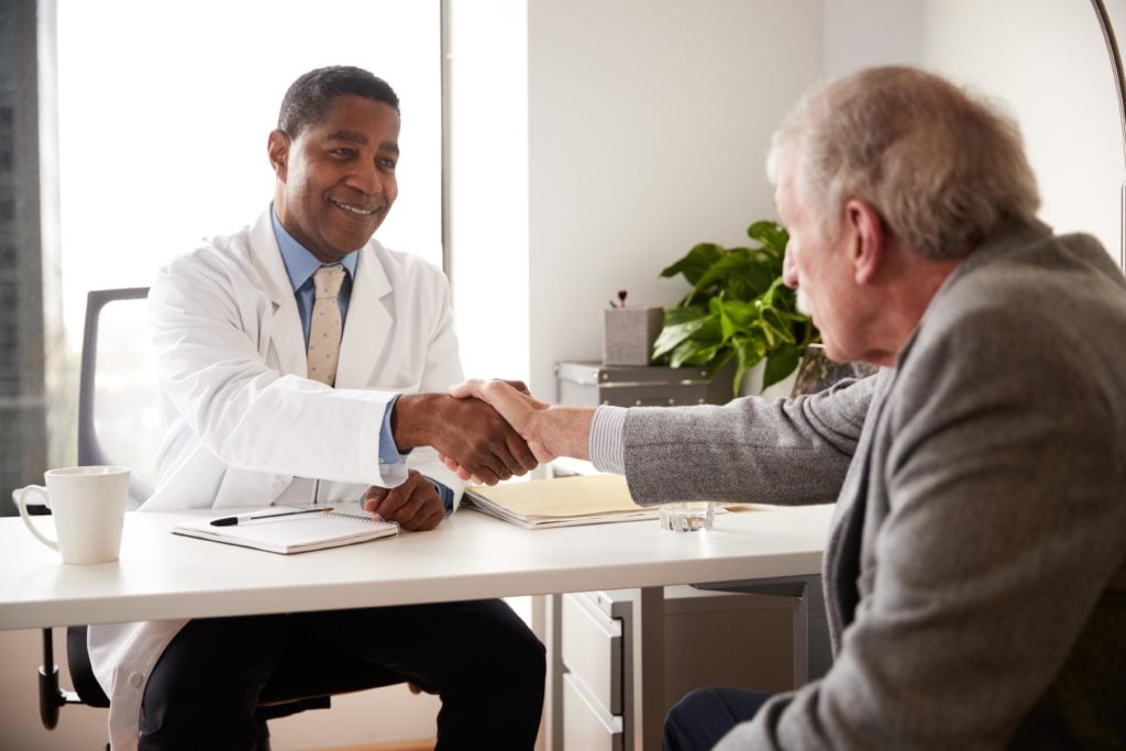 Doctor meeting with senior man to discuss warning signs and symptoms of dementia